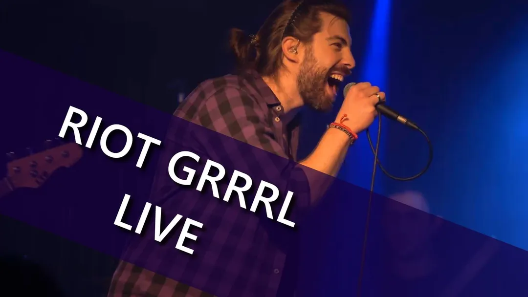 A person sings looking to the right. Riot Grrrl Live is written at the bottom left.